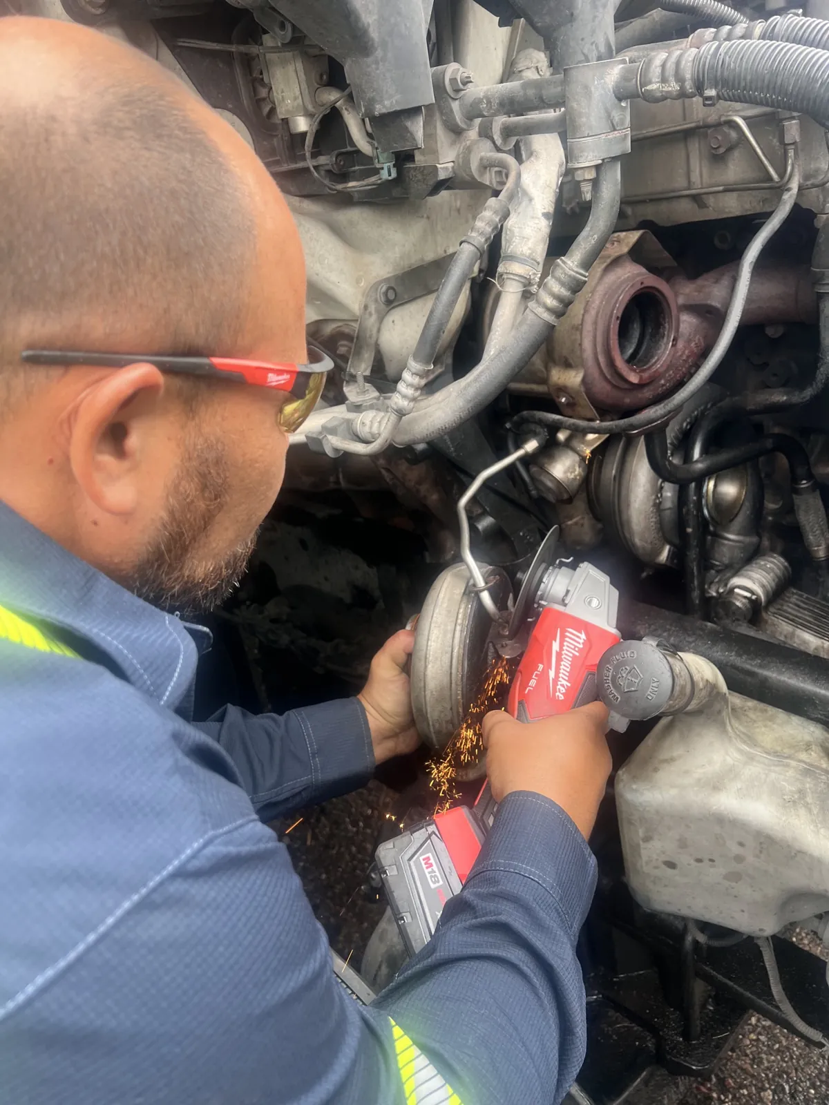 Diesel engine repair in Tucson - technician cutting and fabricating on a truck engine
